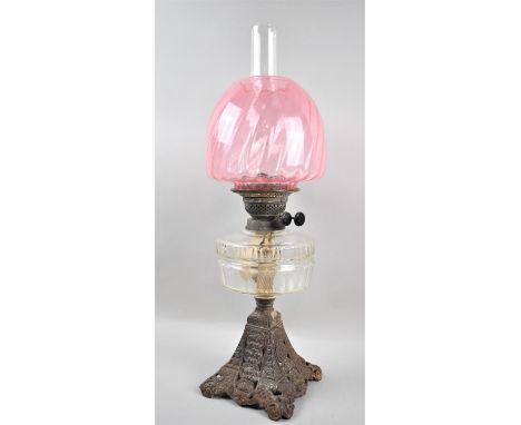 A Late Victorian Iron Based Oil Lamp with Clear Glass Reservoir and Cranberry Glass Shade, Overall Height 60cm 