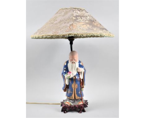 A Chinese Figural Table Lamp in the Form of Shou Lao Holding Peach of Longevity, Complete with Shade 