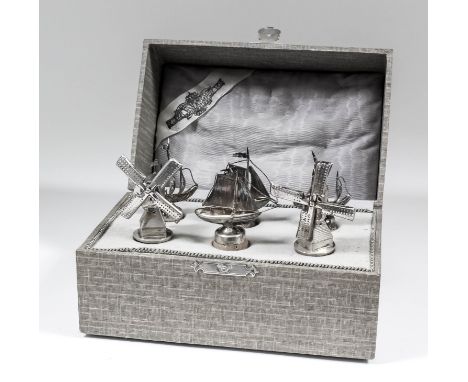 Six Dutch silvery metal bottle stoppers, four modeled as ships and two modeled as windmills, contained in cloth covered fitte