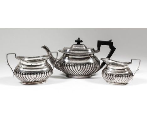 An Edward VII silver oval three piece tea service with gadroon mounts, part reeded bodies and angular loop handles, comprisin