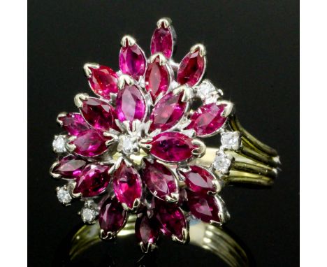 A modern 14ct gold mounted ruby and diamond  dress ring of flowerhead design, the face set with twenty-two small leaf cut rub