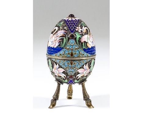 An early 20th Century Russian silver gilt and champleve enamel egg pattern box set with seven garnet cabochons and enamelled 