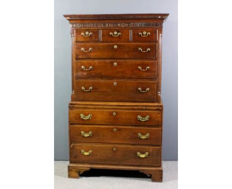 An 18th Century "Cardiganshire" oak tallboy, the upper part with dentil moulded cornice, blind fret carved frieze, fitted thr