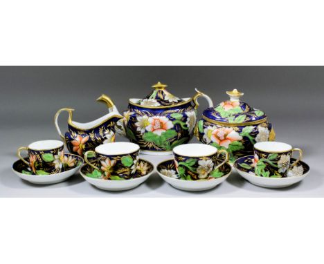 An early 19th Century English bone china part tea service painted in colours and gilt, on blue ground, with waterlilies and f
