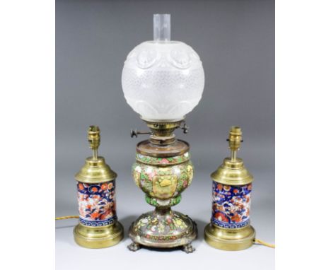 A late 19th Century pottery oil lamp with gilt metal fittings, the body enamelled in colours and gilt with flowering branches