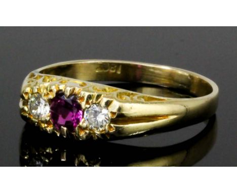 An 18ct gold mounted ruby and diamond three stone dress ring in the "Victorian" manner, set with central ruby flanked by diam