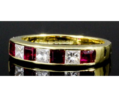 A modern 18ct gold ruby and diamond half hoop eternity ring set with four baguette cut rubies, separated by four brilliant cu