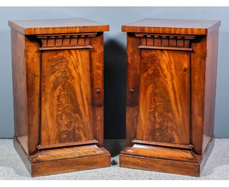 A pair of George IV figured mahogany pedestal cupboards with square top edges, one fitted with an interior drawer and two sli