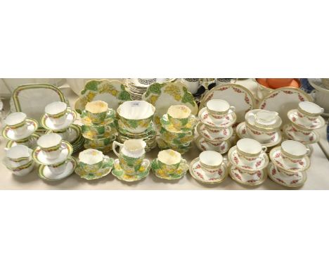 A Edwardian Foley type tea service, yellow flowers on a green ground; a Staffordshire tea service, green borders; another, wi