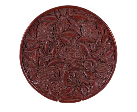  A large Chinese red lacquer tray,   in Ming style, of shallow circular form, the interior deeply carved with four large flow