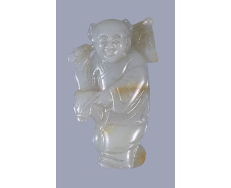  A Chinese pale celadon and russet jade carving of boy  , riding a hobby horse and holding a flag across one shoulder, 5.8cm 