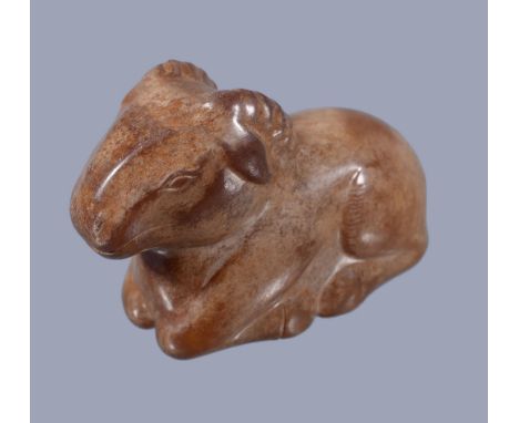  A Chinese brown jade ram,   recumbent with legs tucked underneath its body, pierced with a hole through the body, 5cm long x