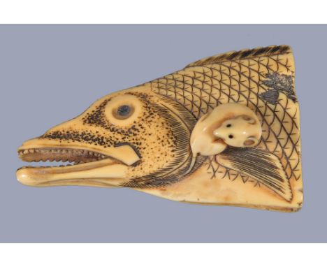 Ω An Ivory Netsuke depicting a rat seated on top of a severed salmon head, the dead eyes of the fish inlaid in horn or ebony,