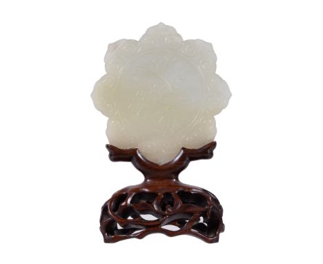  A Chinese white jade flower plaque,   carved on one side with lilies and the other side with floral spiral, 7.8cm diameter, 