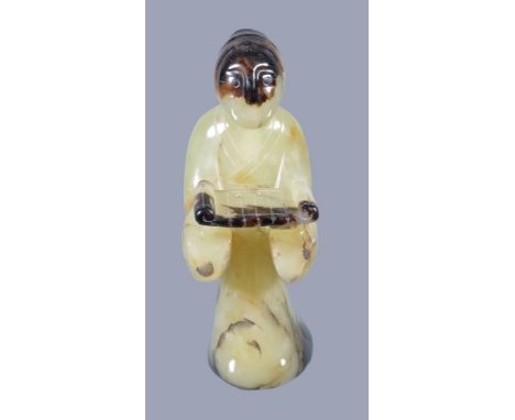  A Chinese yellow jade figure,   20th century, standing holding a tray, with brown inclusions, 10cm high 