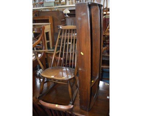 AN ERCOL DARK BEECHWOOD ROCKING CHAIR with spindle back and shaped top splat, a matching plate rack and a Jaycee carved oak g