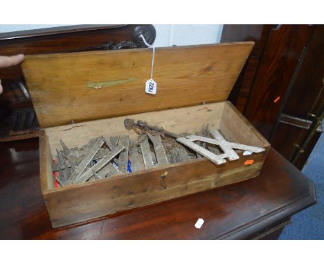 A VINTAGE PINE BOX containing cast iron Roman numeral golf markers