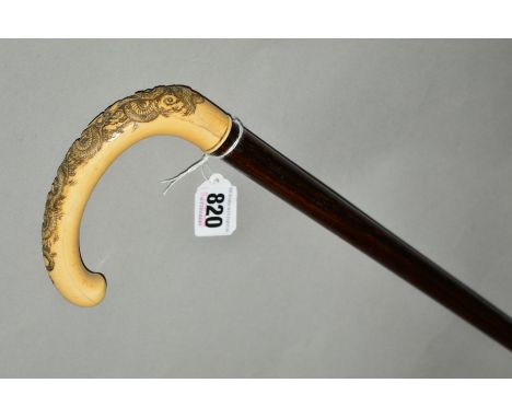 A LATE 19TH CENTURY IVORY HANDLED WALKING STICK, carved with scrolling dragon and clouds, length 91cm