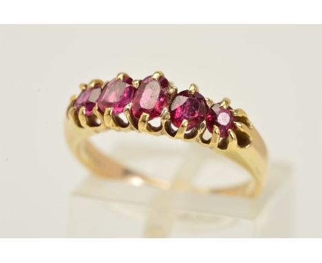 A FIVE STONE GARNET RING, designed as a graduated row of five oval and circular garnets within claw settings, ring size K, ap