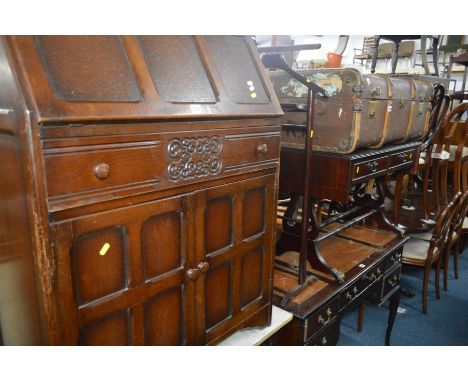 AN OAK FALL FRONT BUREAU together with a mahogany sofa table with two drawers, mahogany suit stand and an oval mirror (4)