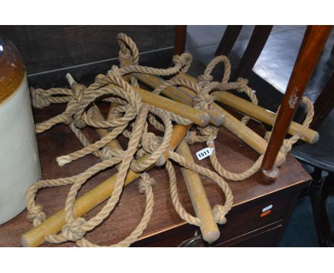 A TEN RUNG ROPE LADDER with beechwood round rungs, a 180cm lead on and made of 16mm rope