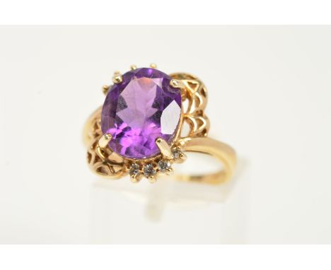 A 9CT GOLD AMETHYST RING, designed as an oval amethyst within a four claw setting, to the part scalloped and part colourless 