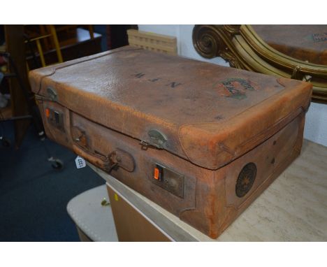 A VINTAGE TAN LEATHER SUITCASE with various travel labels, width 71cm x depth 41cm x height 22cm