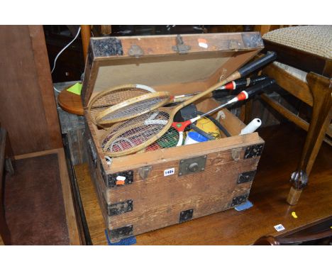 A SMALL VINTAGE PINE TRUNK with steel banding to corners, a brass lock assembly (no key) and containing vintage sporting equi