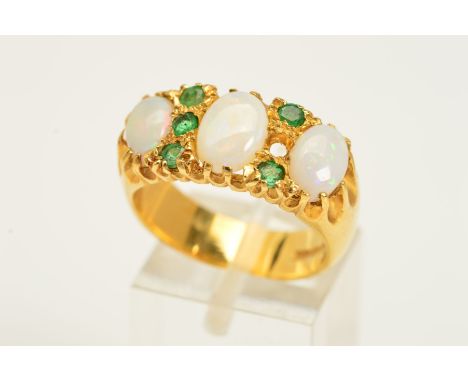 AN 18CT GOLD OPAL AND EMERALD RING, designed as three graduated oval opals, the central opal flanked by a vertical row of thr