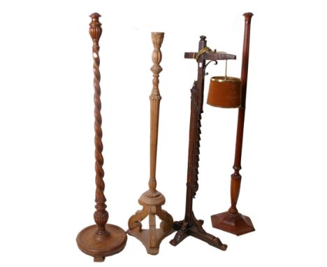 An early 20th Century oak adjustable standard lamp, together with three further carved standard lamps (4)