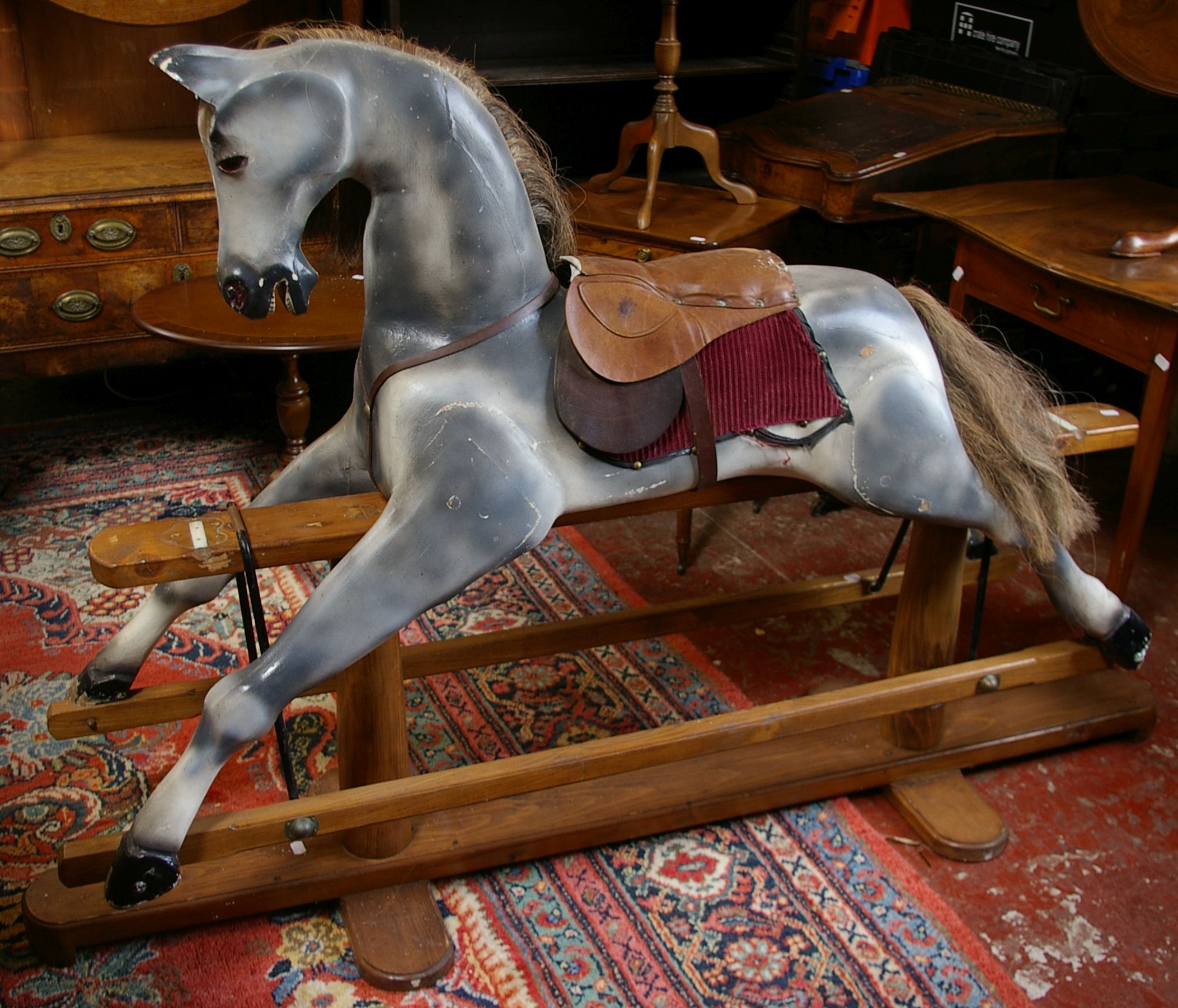 A Victorian style rocking horse on swing stand, dapple grey in wood and
