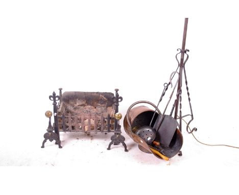 A wrought iron standard lamp, copper scuttle, pair of andirons and fire basket with Prince of Wales feathers and further fire