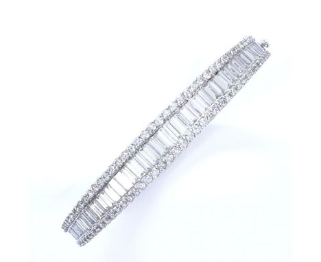 A 7.5ct diamond cluster hinged bangle/bracelet, set with graduated baguette diamonds within a round brilliant diamond frame i