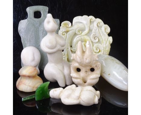 A collection of stone carvings, including Chinese jade, South American carvings, and Maori green stone 