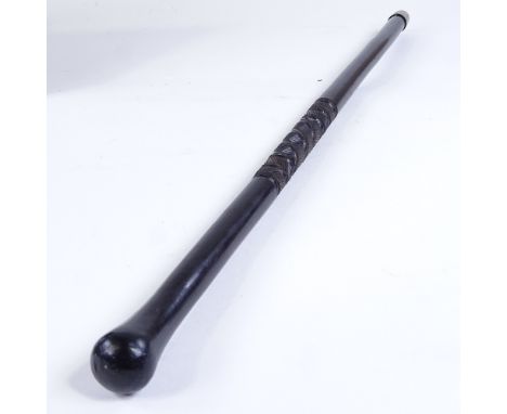 An ebony baton stick with spiral carved design, possibly military, length 61cm 
