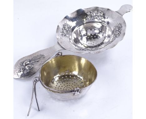 A Swedish swing-handled silver tea strainer, dated 1886, and another Swedish decorative tea strainer, by C G Hallberg, dated 