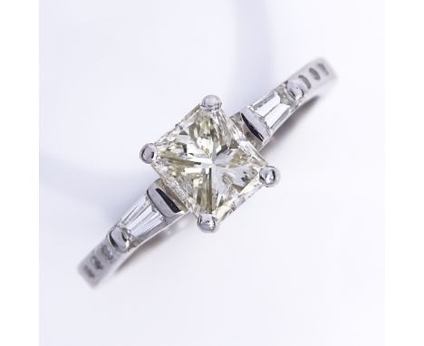 An 18ct white gold 0.75ct modified square brilliant-cut solitaire diamond ring, flanked by tapered baguette-cut diamonds with