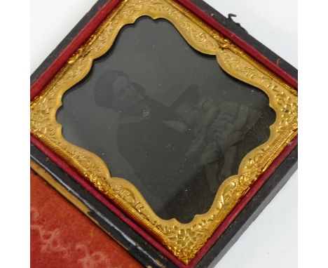 A 19th century tin-type North American photograph, portrait of a woman feeding a baby,  in original embossed leather case, ca