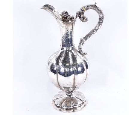 A William IV silver baluster Claret/hot water jug, lobed form with allover foliate engraved decoration, grape finial and scro