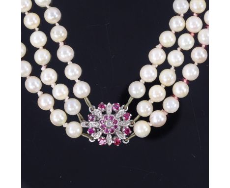 A triple-row cultured pearl ruby and diamond necklace, with pearls measuring approx 6.4mm, on an unmarked white metal ruby an