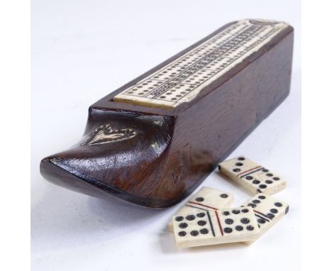 A 19th century carved wood shoe design games box, with bone cribbage board sliding lid enclosing a set of miniature bone domi