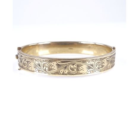 A mid-20th century 9ct gold hinged bangle, engraved foliate decoration, hallmarks Birmingham 1961, band width 10mm, internal 