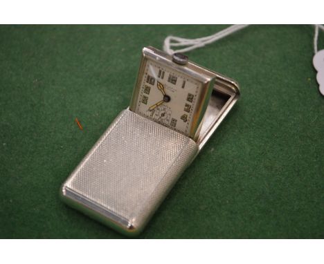 A small silver pop up travelling clock.