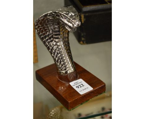 A small chrome plated model of a cobras head.