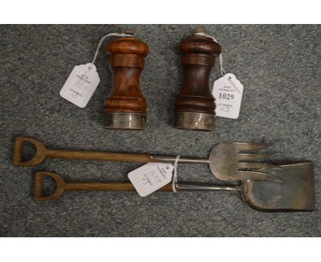 A pair of silver banded pepper mills and a pair of novelty salad servers fashioned as a spade and fork.