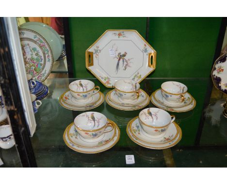 Decorative porcelain tea service comprising five cups, saucers and plates and a cake plate.