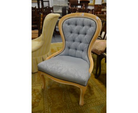 A modern blue upholstered button back bedroom chair.