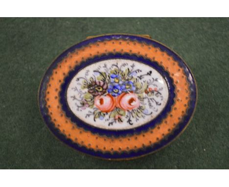 A small gilt and enamel oval patch box.