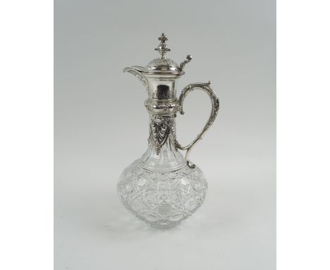CLARET JUG, late 19th century German cut glass with decoratively embossed silver handle, collar and cover, with a gilt interi