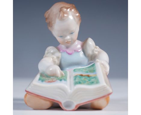 Herend porcelain figurine depicting a young girl engrossed in a picture book. Hand-painted in soft pastel tones with delicate